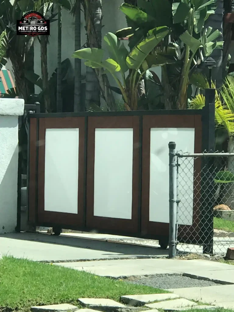 Contemporary driveway gate with wood and frosted panels installed by Metro GDS