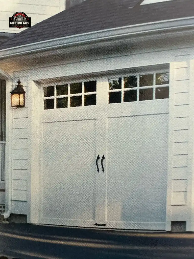 Classic white carriage-style garage doors with glass panels, installed by Metro GDS Inc