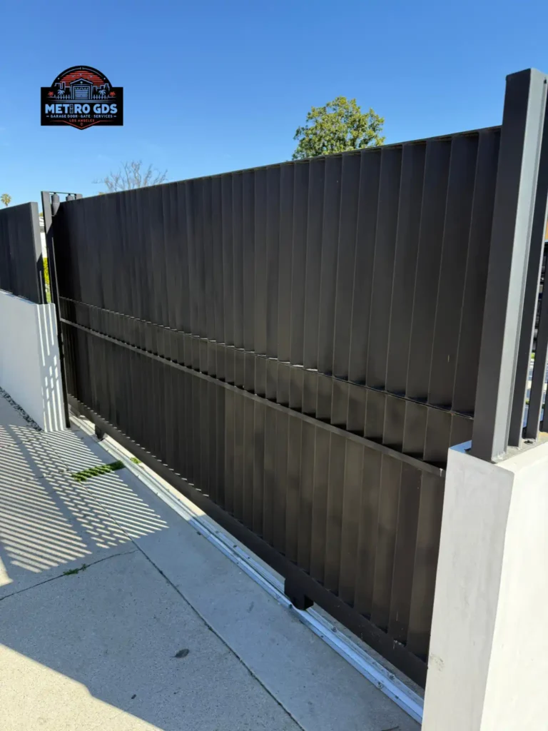 Sleek black slatted metal gate installed by Metro GDS Inc