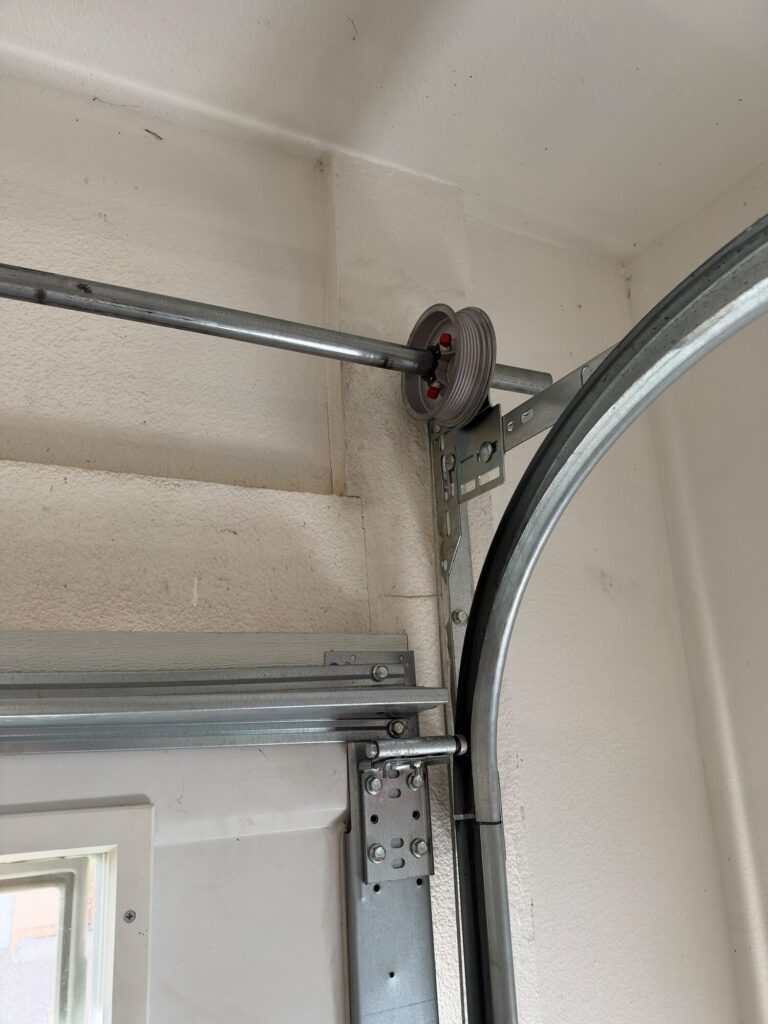 Garage door cable drum and bottom bracket at the track, serviced by Metro GDS in Los Angeles