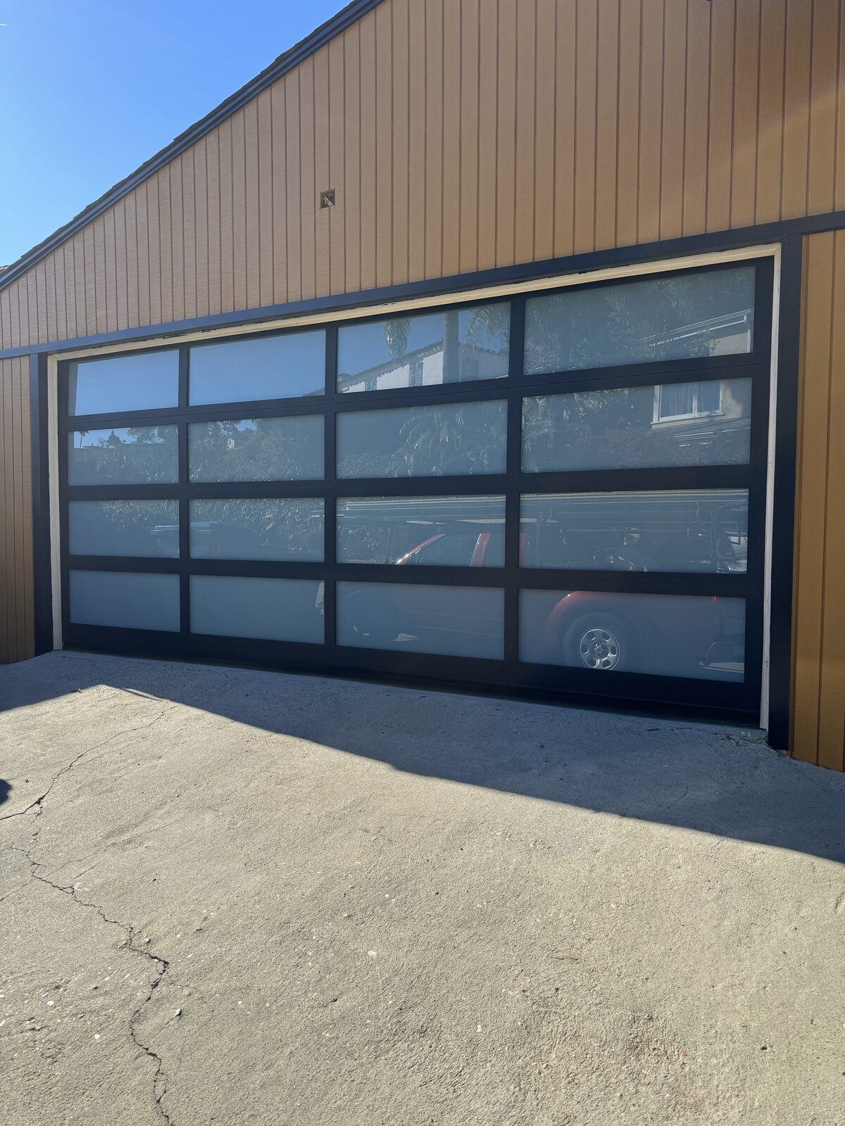Black aluminum and frosted glass garage door installed by Metro GDS in Los Angeles
