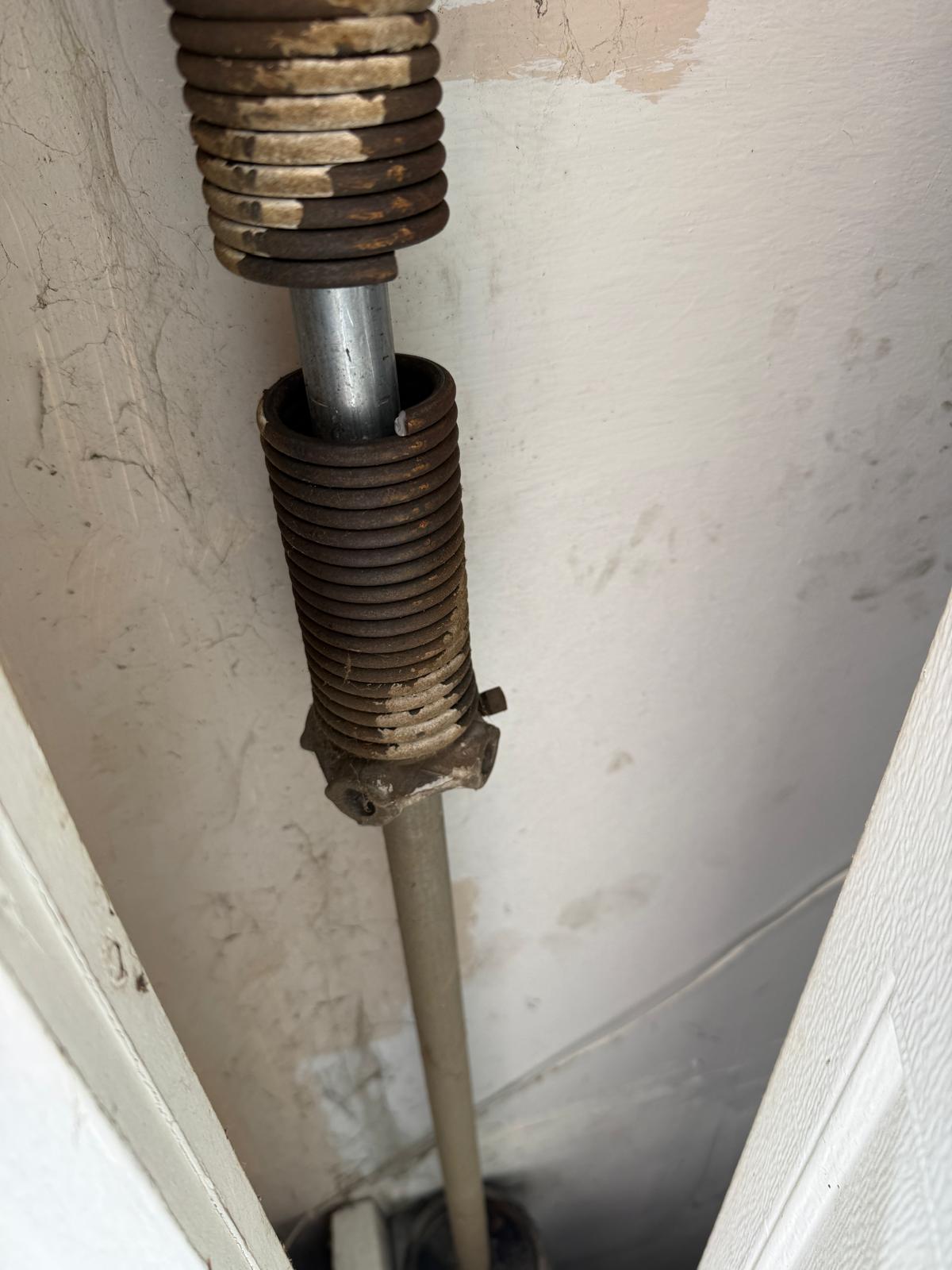 Broken garage door torsion spring on the shaft, close-up, Metro GDS Inc Los Angeles