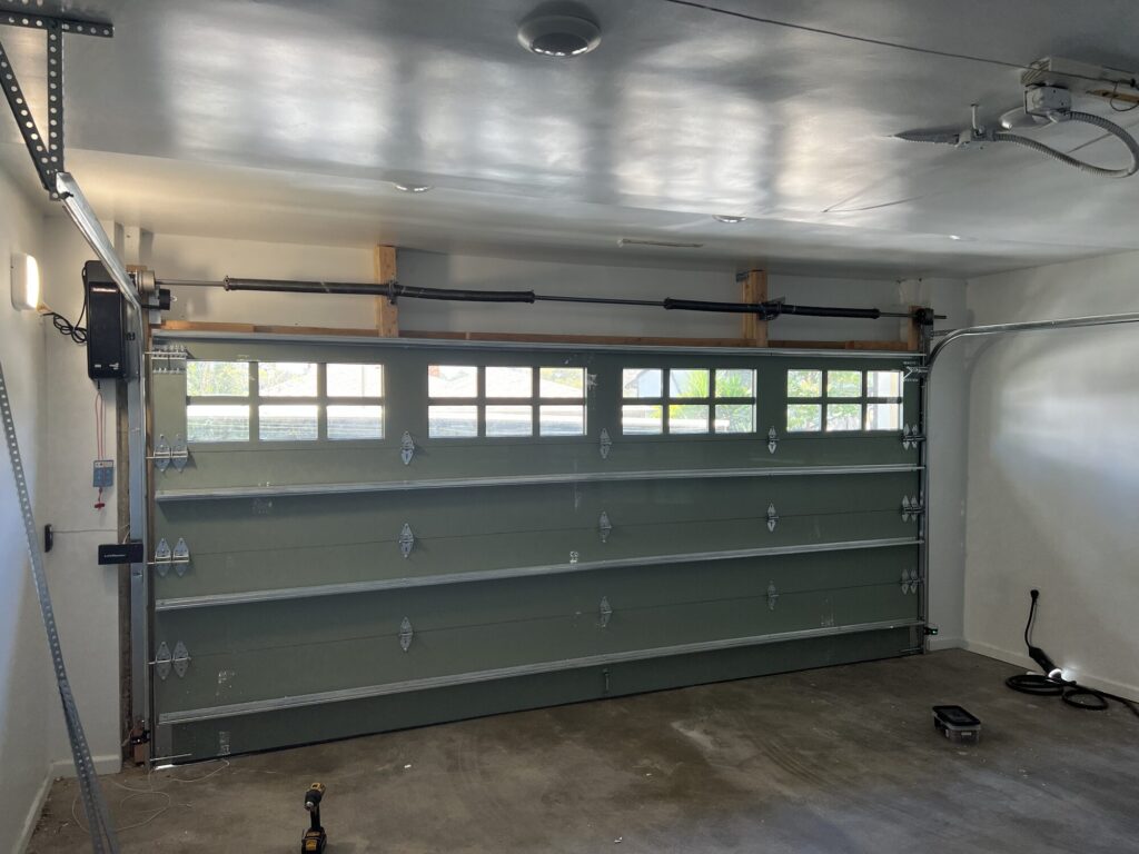 Inside a garage showing a sectional door with opener rail and track installed by Metro GDS in Los Angeles