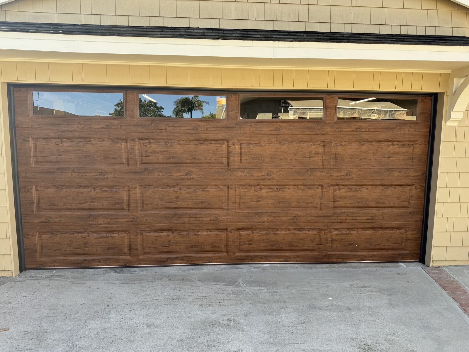 Wood-grain carriage style garage door with windows installed by Metro GDS in Los Angeles
