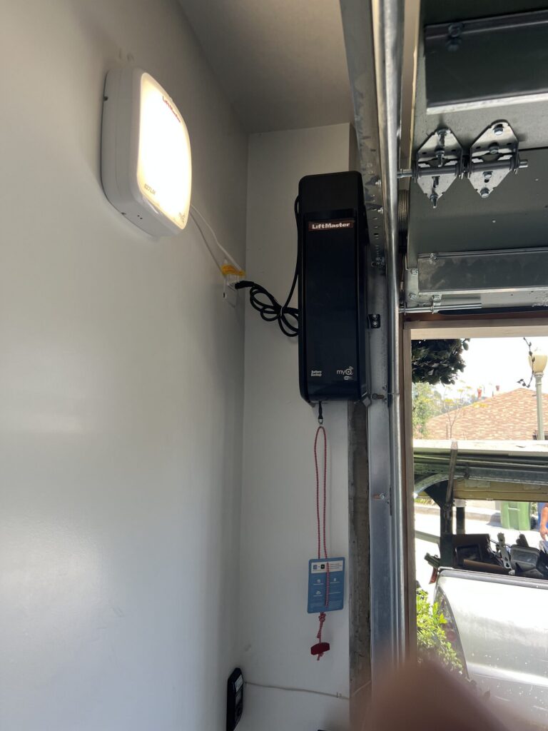Garage door opener head unit with wall control mounted in a garage by Metro GDS in Los Angeles