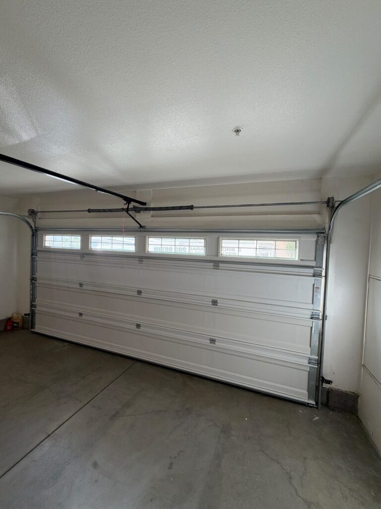 Garage door opener rail above a sectional door with torsion shaft, serviced by Metro GDS in Los Angeles